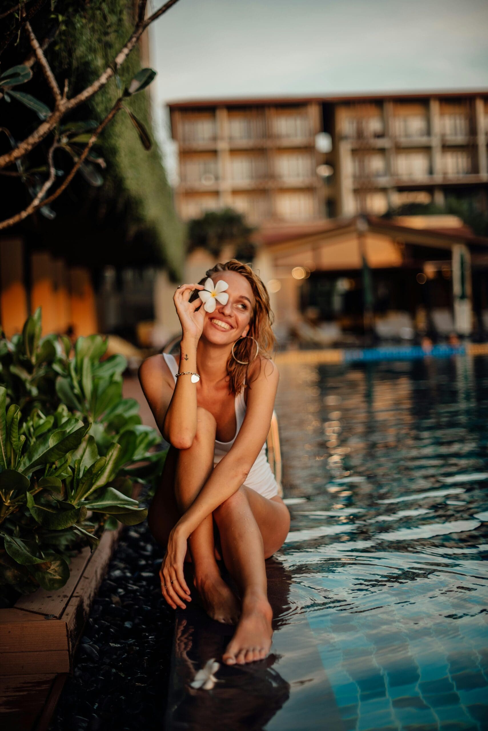 Smiling woman by the bool at a luxury yoga retreat resort