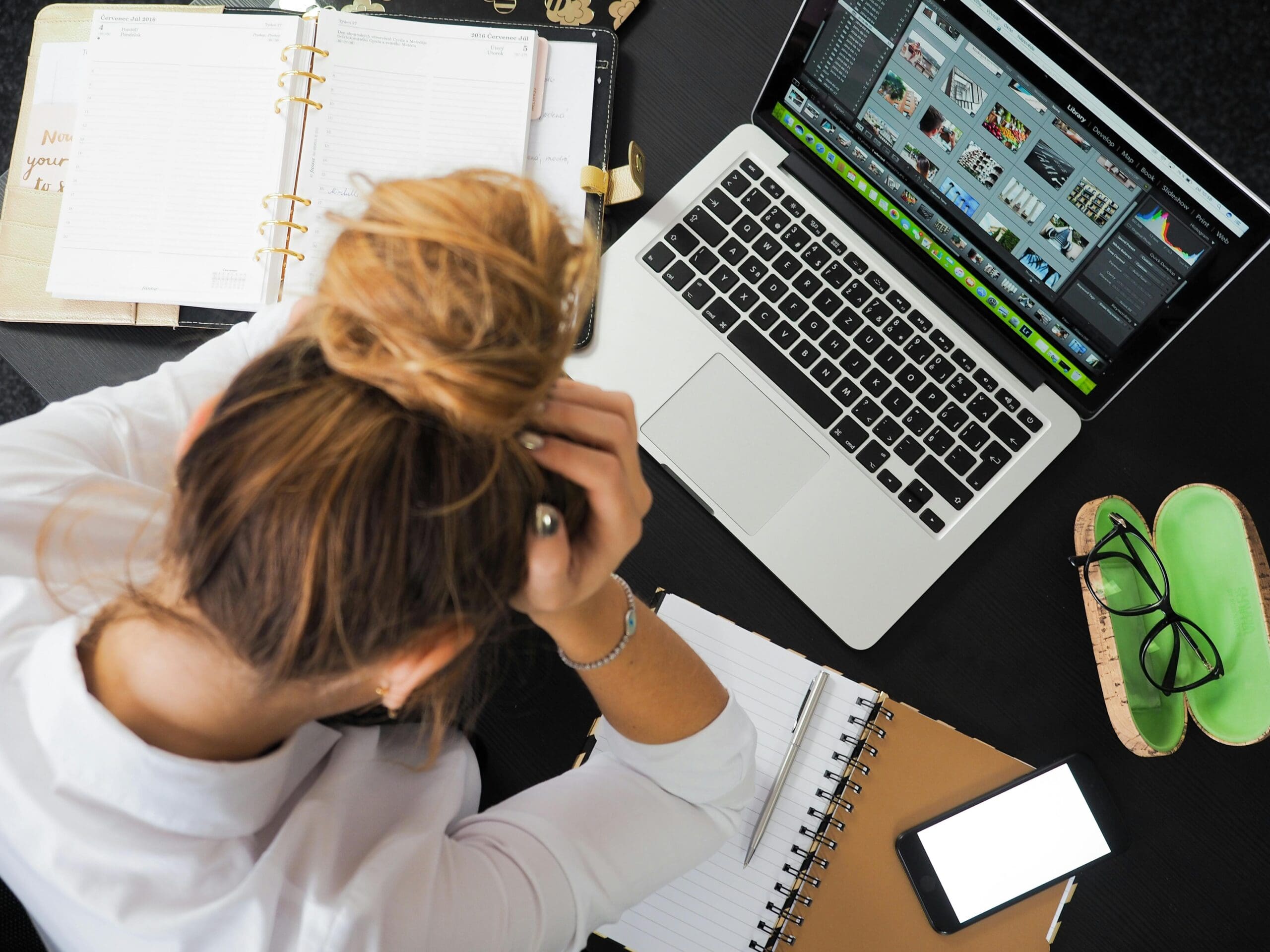 Creative business owner working at a computer with notebooks and planners nearby
