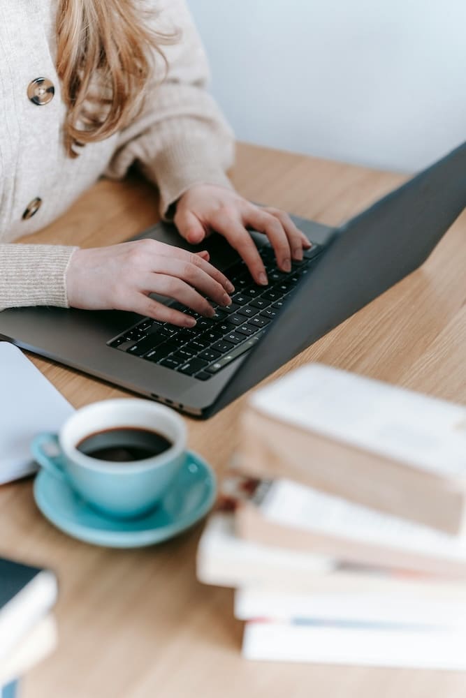 Woman working on website design customization at desk with laptop